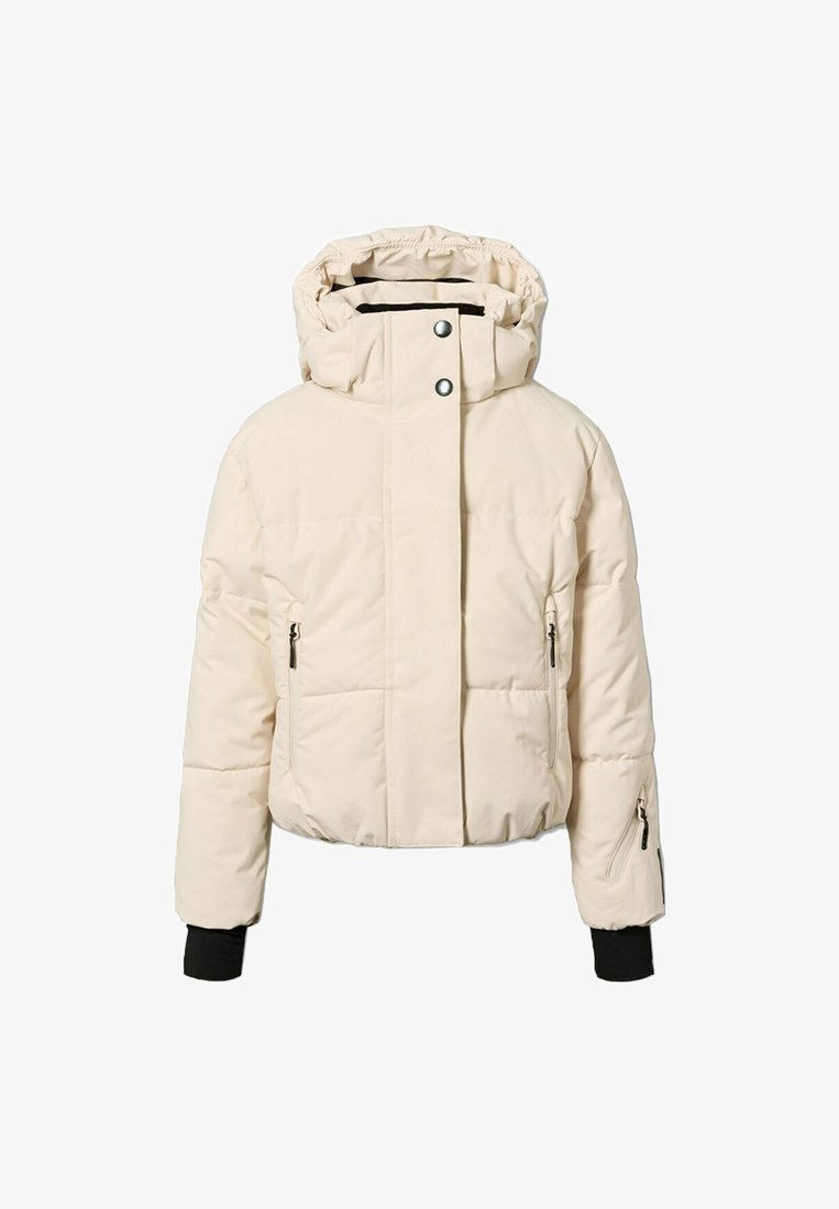 Giubbotto imbottito color crema con cappuccio, bottoni a pressione, due tasche frontali con zip e polsini a coste. Texture liscia e trapuntata.