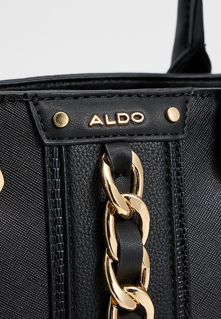 Borsa nera realizzata in materiale sintetico tessurizzato, con un accento in catena dorata, logo impresso e dettagli in hardware tono oro.