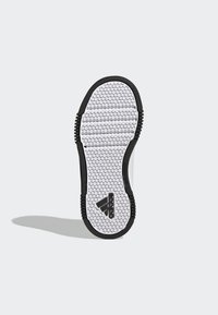 Såle med svarte gummikanter, teksturert hvit sekskantet mønster, og svarte logo detaljer på siden. Rent design, flat form.
