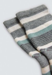 Calcetines a rayas en tonos gris y verde azulado con textura acanalada, que presentan rayas horizontales de diferentes anchos y una composición de tela suave.