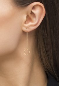 Gullørne dråpeøreringer med en tynn kjede og en sirkulær aksent, som fremhever et minimalistisk design med glatt tekstur.