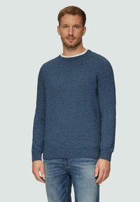 Niebieski sweter dzianinowy z okrągłym dekoltem i długimi rękawami. Miękka faktura; ma prążkowane mankiety i dół. Noszony na białej koszuli.