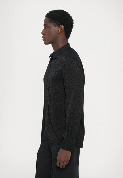 Black button-up shirt with a subtle textured pattern, featuring a classic collar and long sleeves, worn with dark trousers.