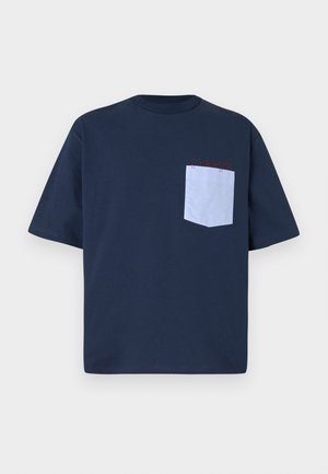 Tumed sinine puuvillane T-särk, millel on helesinine rinna-tasku punaste õmblustega ja sildiga. Lühikesed varrukad ja ümmargune kaelus.