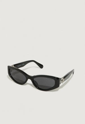 Gafas de sol negras con forma de ojo de gato, montura de plástico brillante, lentes oscuros y detalle de hardware plateado en las patillas.
