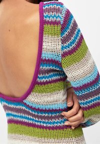 Pull en tricot avec un dos dégagé, rayures multicolores en bleu, vert, violet et blanc, avec un design ample et texturé.