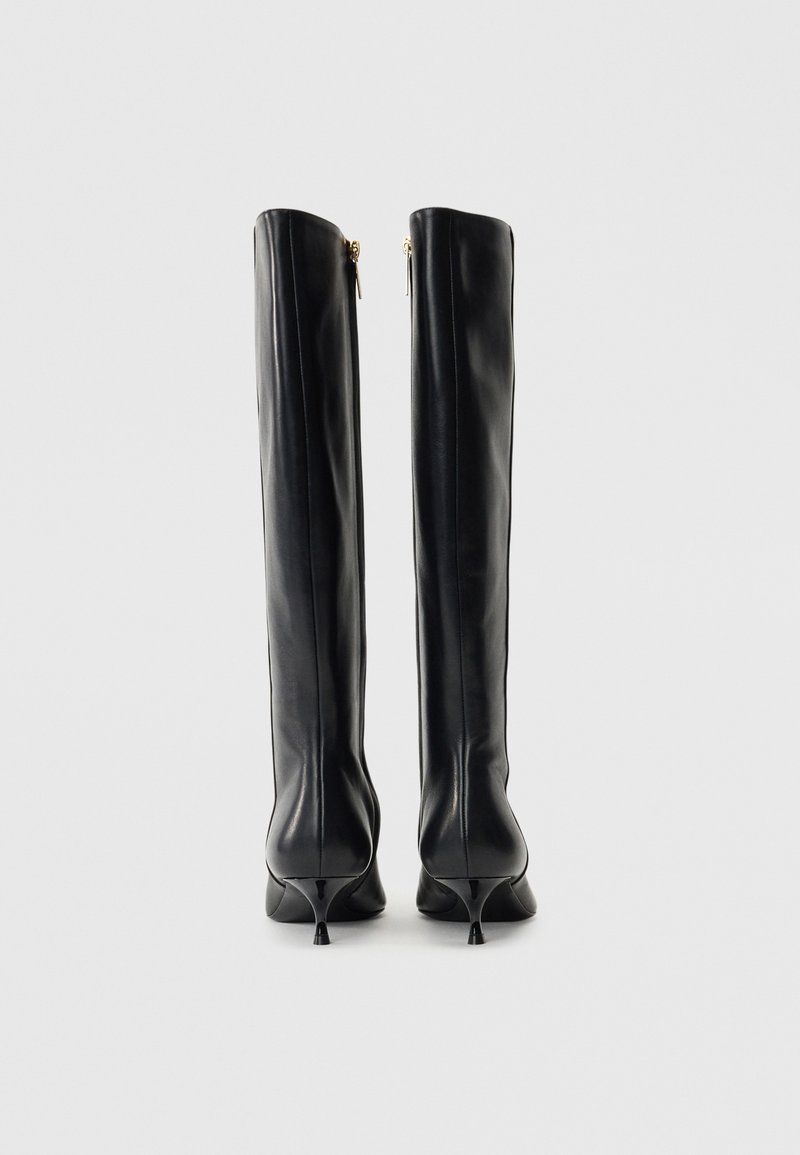 Knähöga svarta läderstövlar med spetsig tå och böjd klack, med dragkedjestängning bak och en slät, glänsande yta.