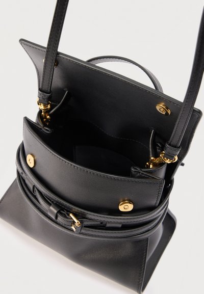 Μαύρο δερμάτινο τσαντάκι χιαστί με χρυσά μεταλλικά στοιχεία, ανοιχτό καπάκι που δείχνει τα εσωτερικά διαμερίσματα και ρυθμιζόμενο λουρί ώμου με αγκράφα.