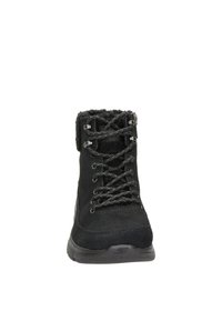 Botín negro hasta el tobillo con exterior de ante, diseño con cordones, forro suave y suela de goma. Presenta ojales de metal y detalles de costura sutil.