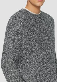 Schwarz-weißer Strickpullover mit strukturiertem Muster, geripptem Ausschnitt und langen Ärmeln, mit lässigem Schnitt und weichem Material.