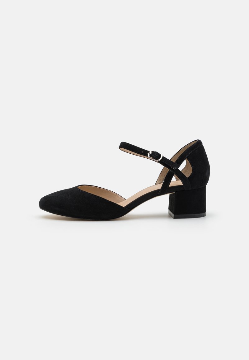 Chaussure noire en daim à talon haut avec un bout pointu et un large talon bloc. Dispose d'une sangle de cheville réglable avec une boucle en argent.