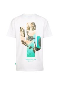 T-shirt en coton blanc avec une grande silhouette de cactus remplie d'un paysage de plage et d'eau bleue, avec "ENSENADA_MX" imprimé en dessous.