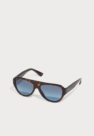 Gafas de sol carey con lentes de gradiente azul oscuro, marco resistente y patillas anchas. Logo de la marca en el lateral; acabado pulido.