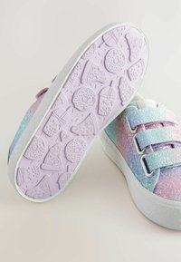 Baskets aux teintes arc-en-ciel avec une texture brillante, dotées d'une semelle blanche et d'une semelle extérieure violette ornée de motifs inspirés de la nourriture. Fermeture sécurisée avec des sangles.