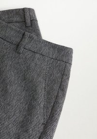 Pantalons gris à motifs avec un tissu texturé, devant plat et taille ajustée comportant de subtils détails de couture.