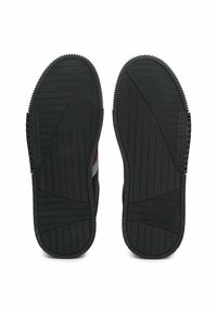 Zwarte rubberen schoenzolen met een textuur voor grip, met een zigzagpatroon. Zijdetails omvatten horizontale strepen in het rood en wit.