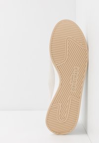 Soletta in gomma marrone con motivo di presa testurizzato, dotata del nome del marchio "Clarks Originals" in rilievo sul lato. Design minimalista.