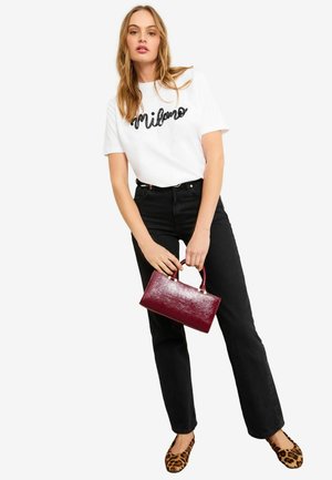 White t-shirt with "Milano" in black script, high-waisted black jeans, leopard print flats, and a glossy burgundy handbag.