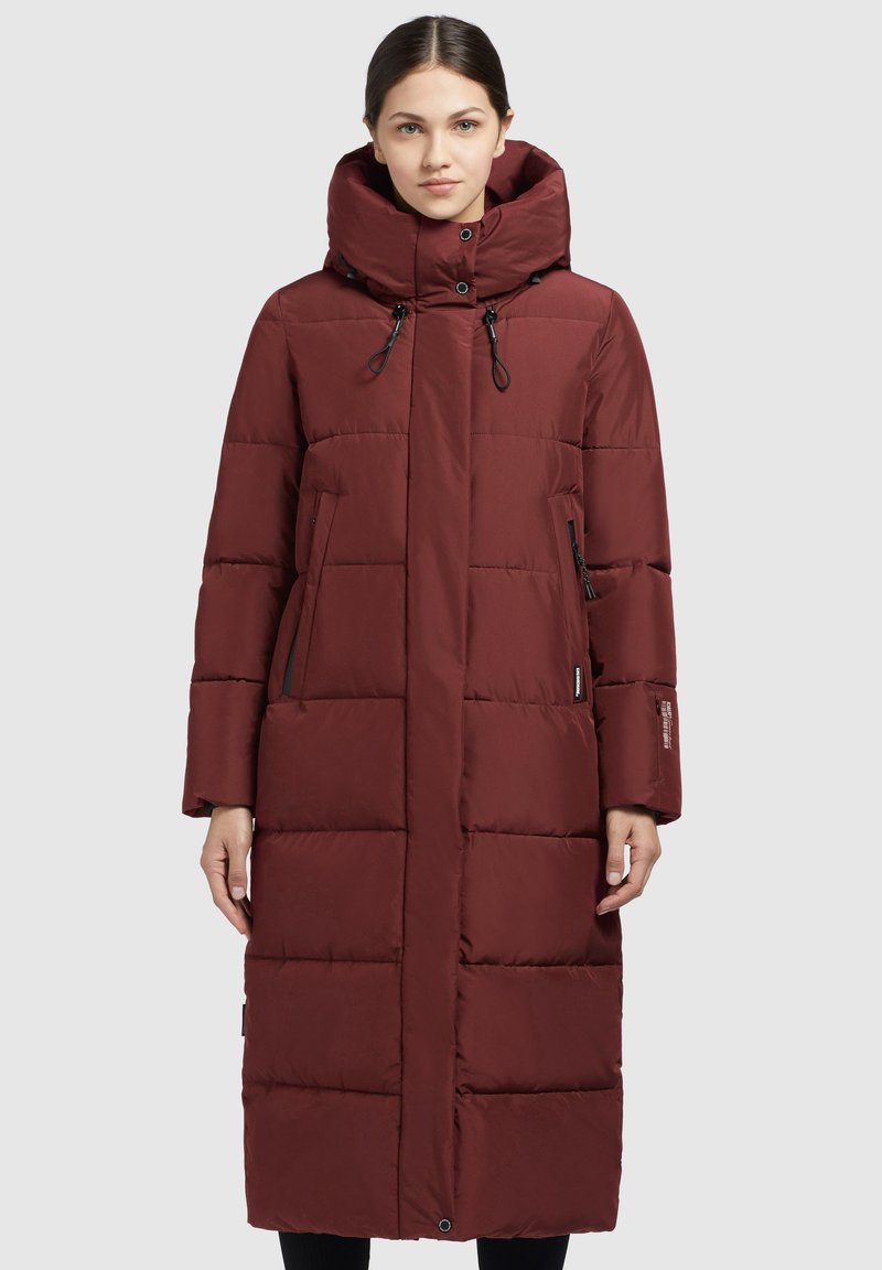 Abrigo largo y acolchado en burdeos con cuello alto y cordón ajustable. Cuenta con cremalleras, bolsillos laterales y una silueta recta. Textura suave.