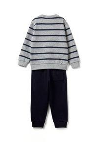 Šedý svetr s dlouhým rukávem a námořnicky modrými vodorovnými pruhy spojený s jednobarevnými námořnicky modrými tepláky, položený na bílém pozadí.