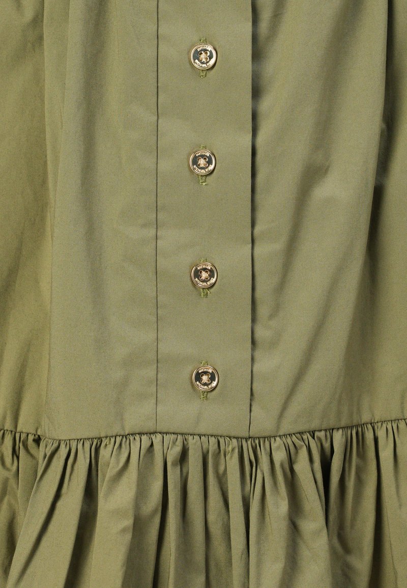 Abito verde oliva con orlo plissettato, caratterizzato da sei bottoni dorati sul davanti e un tessuto liscio e testurizzato.