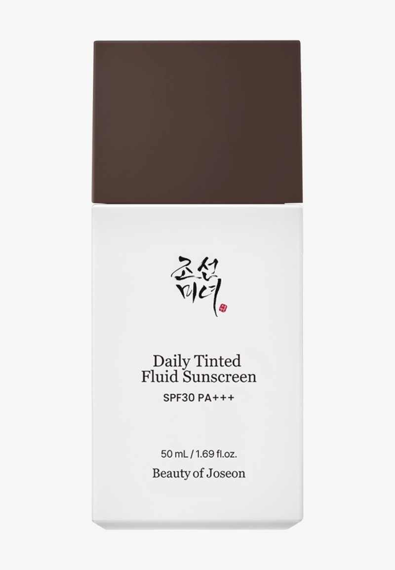 Weiße rechteckige Flasche mit braunem Verschluss. Vorderseitiger Text beinhaltet "Daily Tinted Fluid Sunscreen", "SPF30 PA+++" und den Markennamen "Beauty of Joseon".