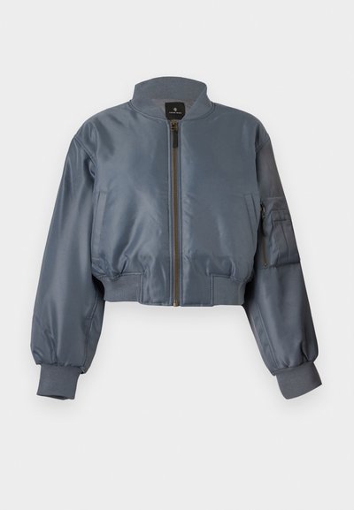 Κοντό γκρι μπουφάν bomber με φερμουάρ εμπρός, ριμπ γιακά, μανσέτες, ζώνη μέσης, πλαϊνές τσέπες και τσέπη με φερμουάρ στο μανίκι σε λευκό φόντο.