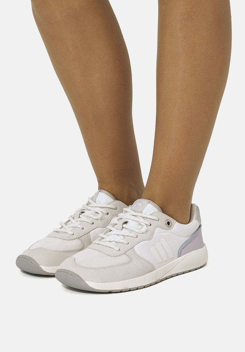 Baskets légères en beige et blanc, avec une tige en mesh et daim, des lacets plats et une semelle en caoutchouc. Détails en violet pastel.