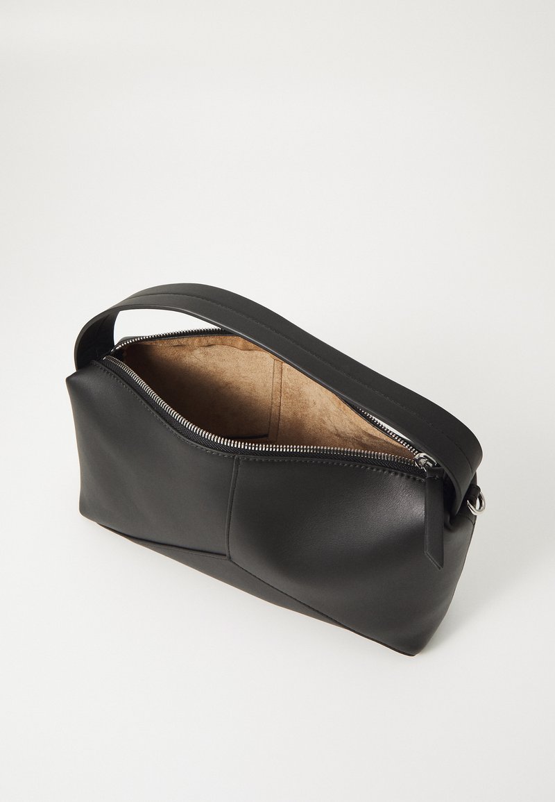 Zwarte leren tas met een elegant, gebogen ontwerp, een ritssluiting aan de bovenkant en een soepele textuur. Het interieur is lichtbruin zonder aanvullende patronen of hardware details.