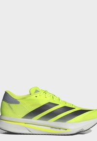Skarpt gul Adidas løbesko med sorte striber, grå hælaccent og hvid sål mærket Lightstrike Pro.