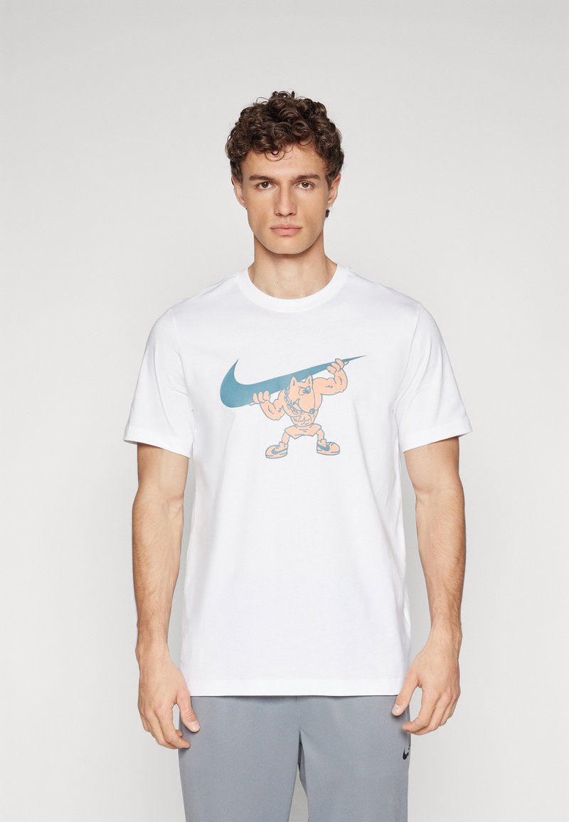 Hvid bomulds t-shirt med et farverigt tegneserie-grafik af en antropomorf karakter, der holder et stort Nike swoosh logo. Korte ærmer, rund hals.