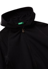Felpa nera con zip e colletto alto. Presenta una texture sottile e una cerniera dorata a contrasto. L'etichetta interna riporta "United Colors of Benetton."