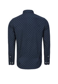 Granatowy, długi rękaw koszuli z kołnierzykiem, zdobiony kropkowanym wzorem w kolorze kremowym. Projekt uzupełniają mankiety na guziki i zaokrąglony dół.