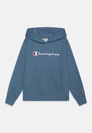 Sudadera con capucha azul hecha de tela suave, con un bolsillo frontal y el logo bordado de "Champion" con detalles en colores.