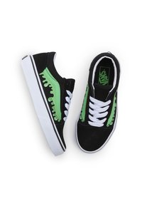 Mustat nubukkikengät, joissa on vihreät korostukset, valkoiset nauhat ja valkoinen kumipohja. Sivulla on graafista yksityiskohtaa.