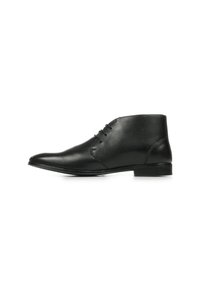 Bottines en cuir noir avec un bout pointu, quatre œillets pour les lacets, texture lisse et un talon bas en bloc. Design simple et épuré.