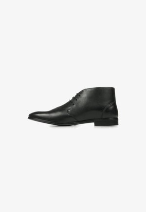Bottines en cuir noir avec un bout pointu, quatre œillets pour les lacets, texture lisse et un talon bas en bloc. Design simple et épuré.