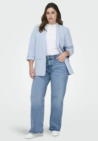 Heled sinine ülikond, millel on lõdvestunud lõige, valge soonikkoes sisu, koos kõrge vöökoha ja heledate siniste teksadega ning valgete tossudega.