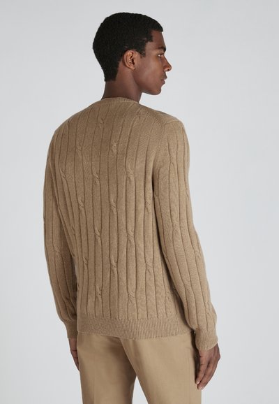 Beiger gestrickter Pullover mit vertikalen Rippenmustern, rundem Ausschnitt und gerippten Bündchen. Hergestellt aus weichem Stoff mit strukturierter Oberfläche.
