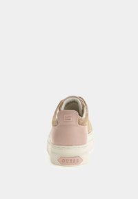 Zapatilla rosa y beige con parte superior de tejido texturizado, capucha de tacón rosa lisa y suela de goma blanca. Logo "GUESS" en el talón.