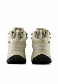 Botas de senderismo de color caqui claro con parte superior de malla texturizada y suela de goma suave. Cuentan con un collarín acolchado y un lazo en el talón para facilitar el uso.