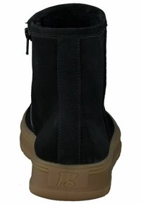 Botín negro con exterior de ante suave y suela de goma. Cierre con cremallera lateral y sutil marca en el tacón.