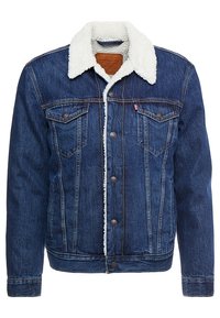 Jeansjacka i mörkblått med en fårskinnskrage. Har knappstängning, två bröstfickor och en distinkt blekt textur.