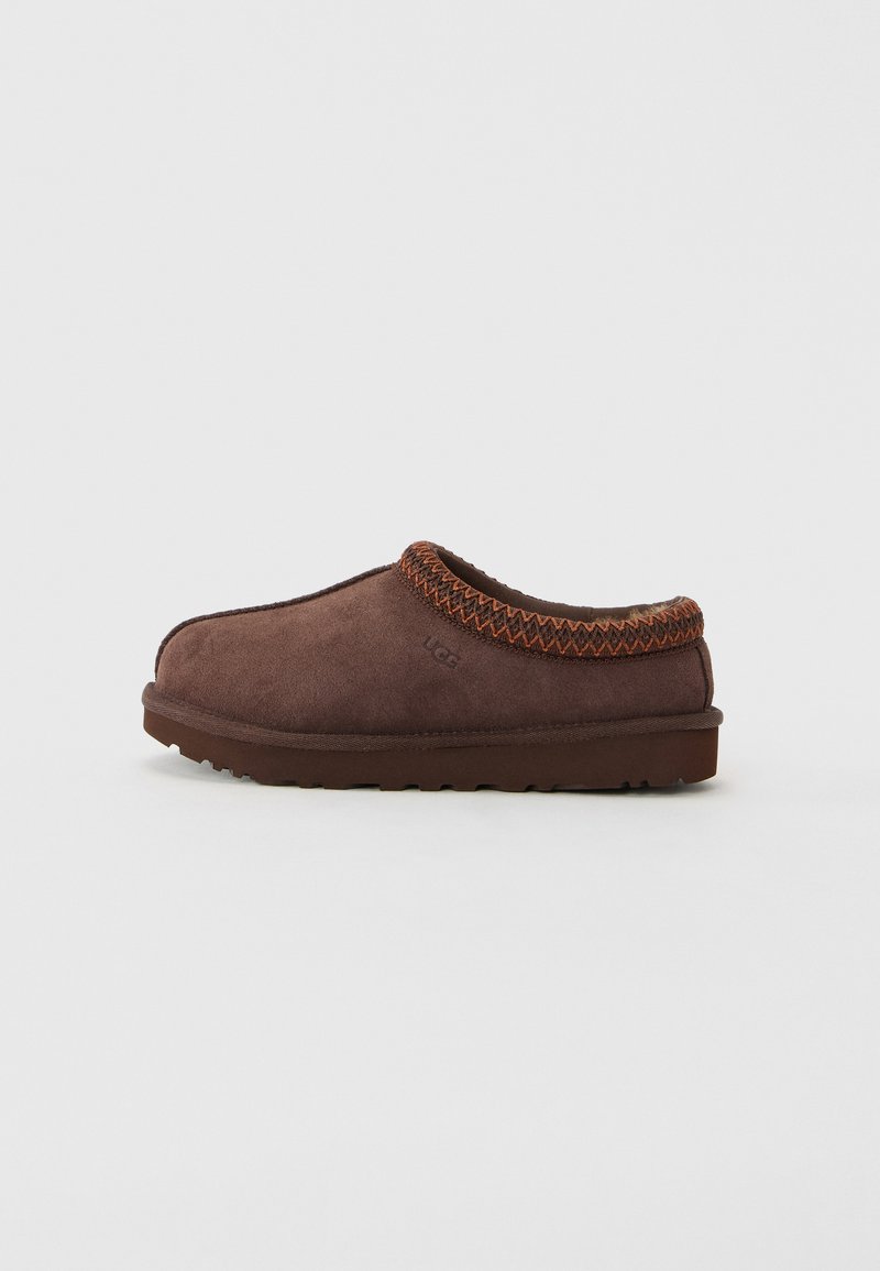 Bruine suède instapslippers met gestikt oranje contrasterend rand en een getextureerde zool, ontworpen voor comfortabel gebruik binnenshuis en buitenshuis.
