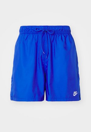 Blå atletiska simshorts med elastiskt midjeband, justerbar dragsko, sidofickor och en vit Nike-logotyp längst ner till höger.
