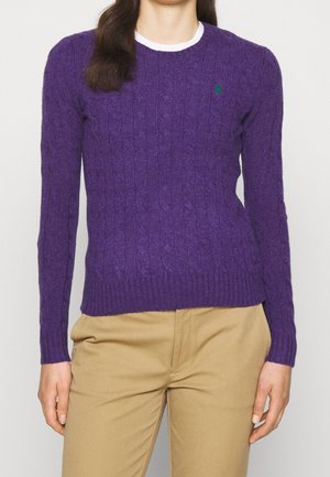 Purple cable-knit sweater with long sleeves, ribbed cuffs and hem. Small green logo on the left chest, layered over a white collar.