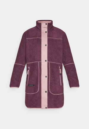 Fleece takki tumman violetissa, jossa on vaaleanpunainen etupaneeli ja yksityiskohtia. Varustettu napilla ja kahdella sivutaskulla vetoketjuilla.