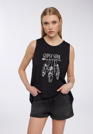 Top nero senza maniche con una vestibilità comoda, caratterizzato da un design grafico bianco di piume e la scritta "GYPSY SOUL." Abbinato a pantaloni corti scuri.