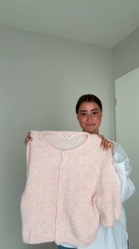 Rosa Cardigan aus weichem, strukturiertem Material, mit rundem Ausschnitt, kurzen puffärmel und einer Knopfleiste vorne.