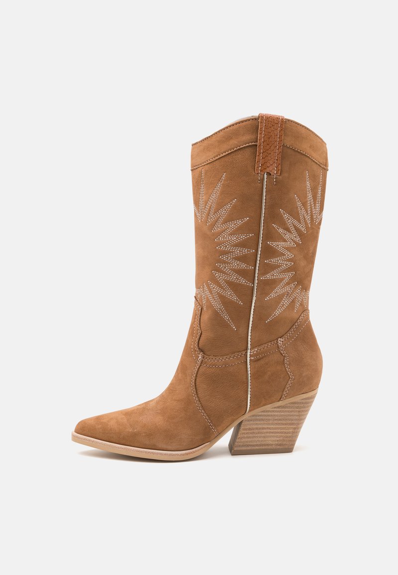 Botas de vaquero de ante marrón con puntera puntiaguda, costuras decorativas en blanco y tacón apilado. Presenta un diseño de estilo western en el caña.
